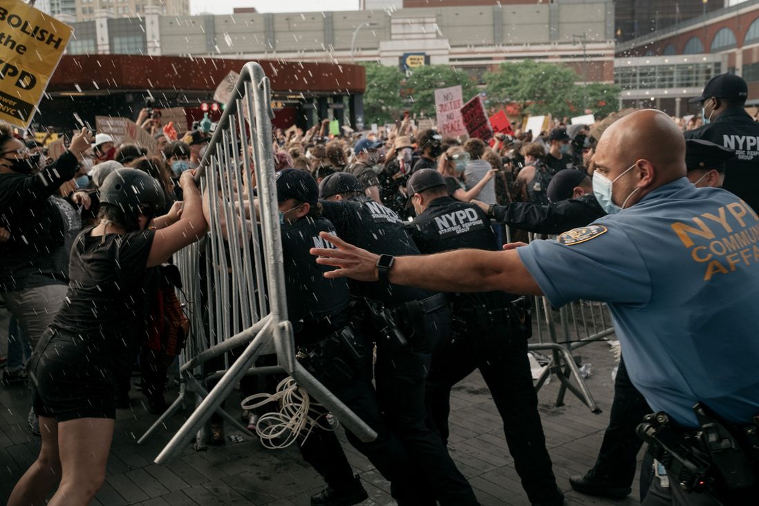 NYPD officers shove a barricade into protesters outside Barclays Center.